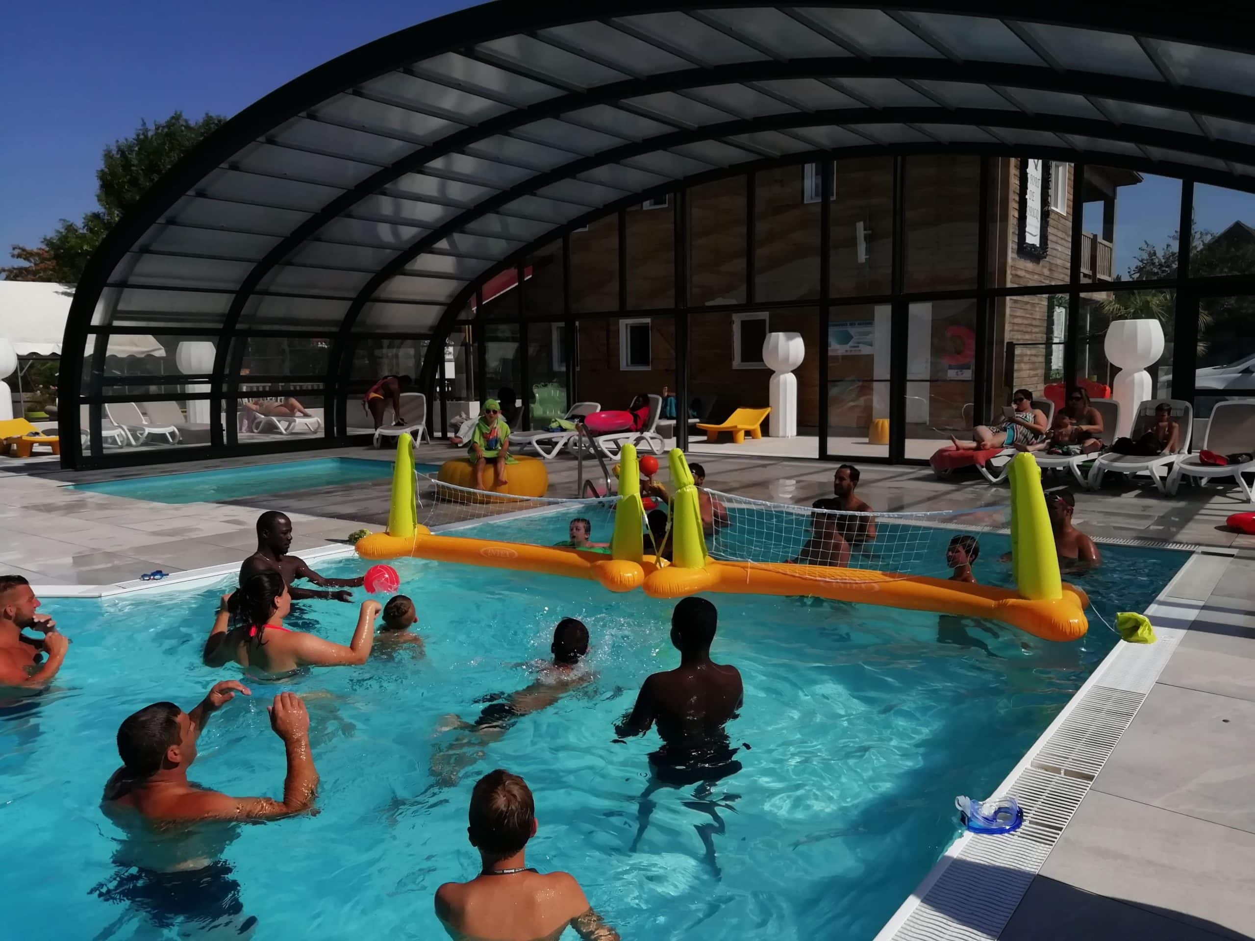 Personnes jouant au volley dans une piscine couverte.