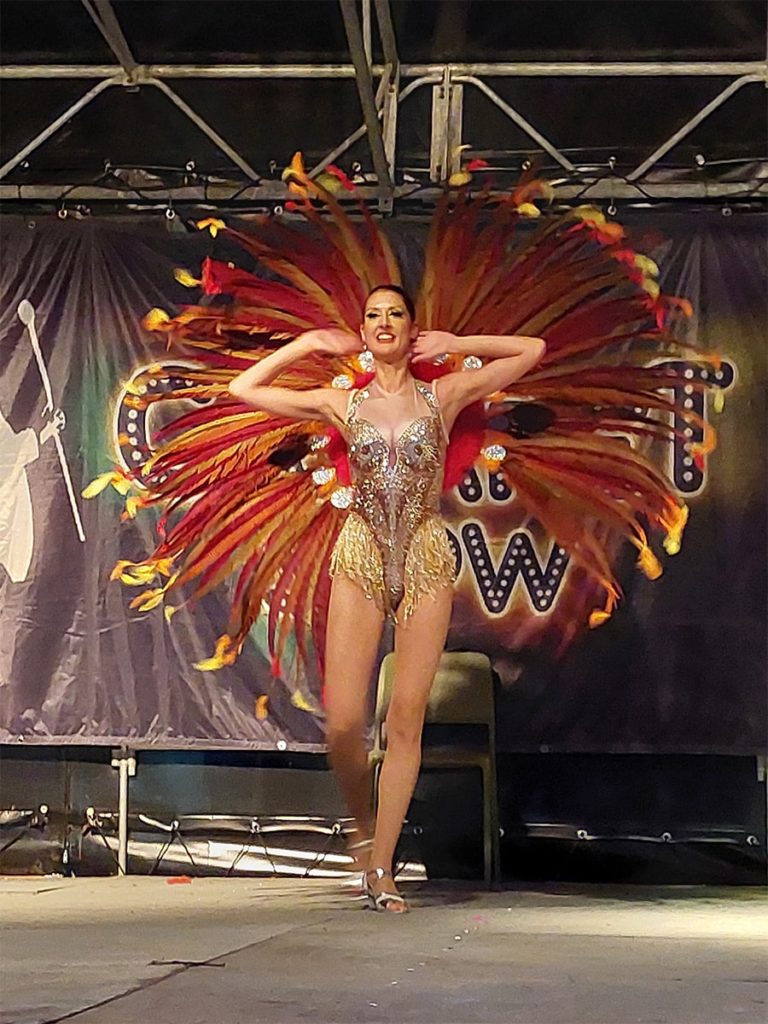 Danseuse de cabaret en costume à plumes colorées.