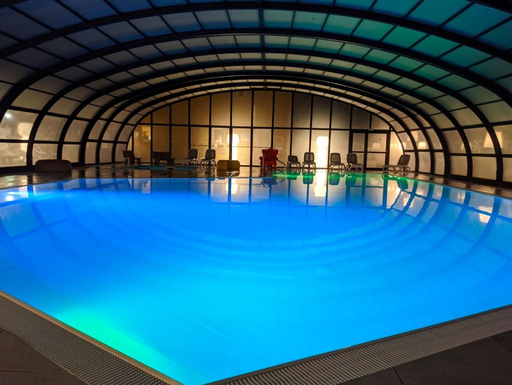 Indoor pool with blue lighting at night.