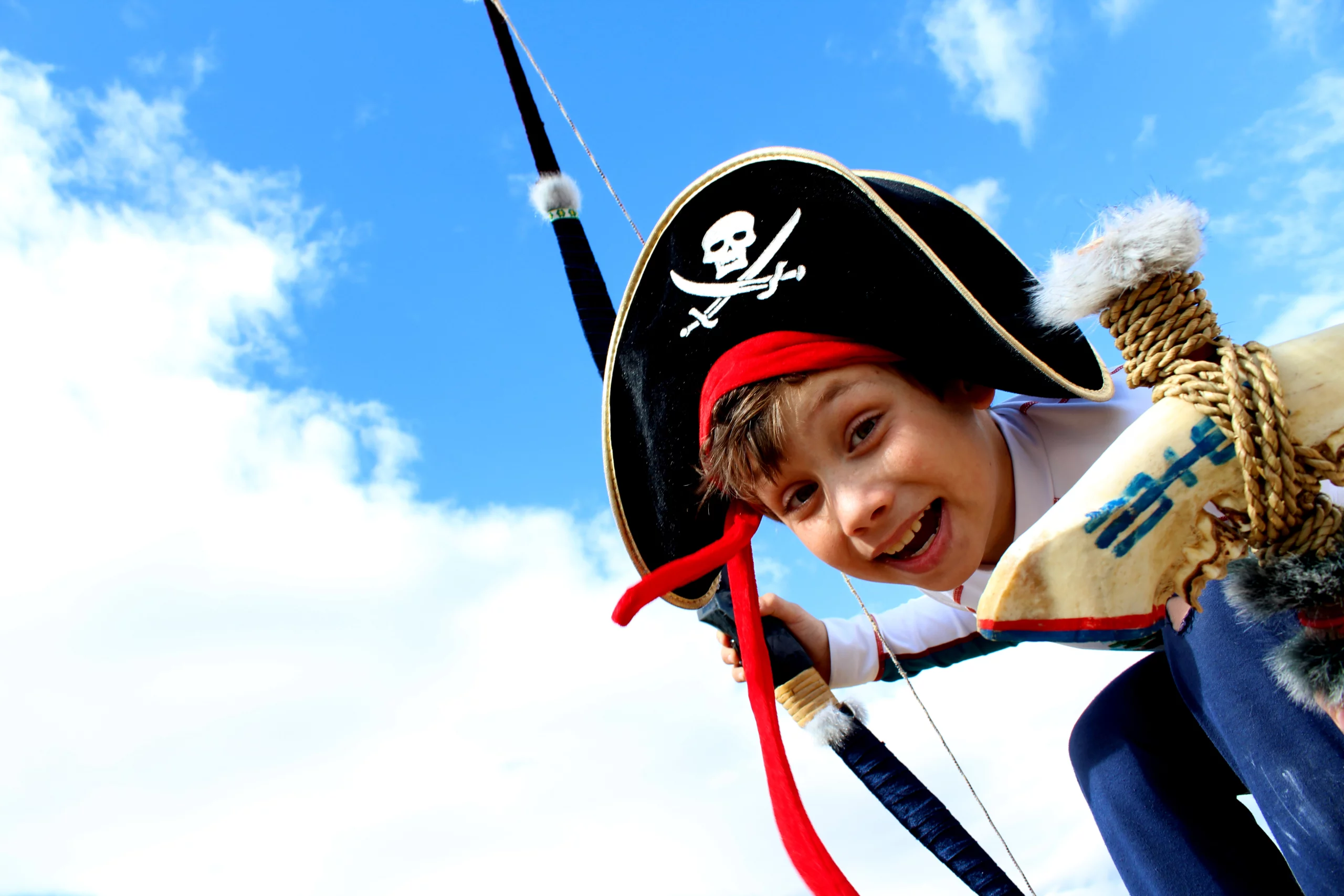 Enfant déguisé en pirate, ciel bleu derrière.