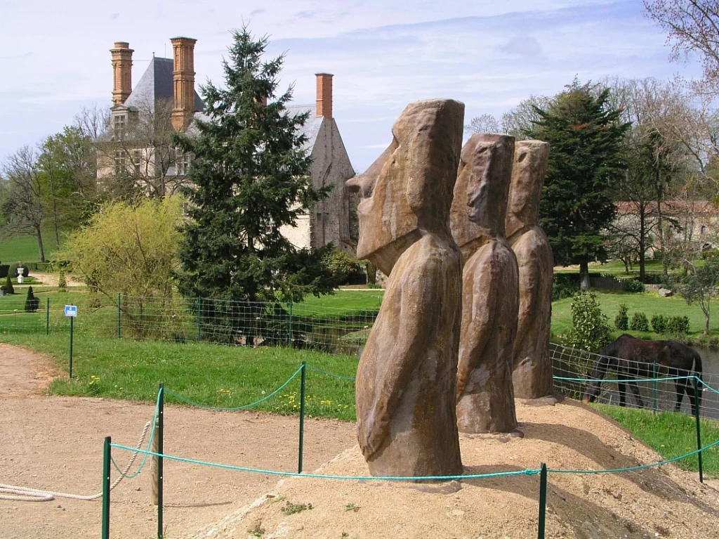 Sculptures de Moaïs devant un château en France.