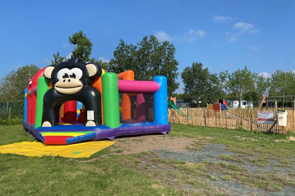 Château gonflable coloré avec singe en plein air.