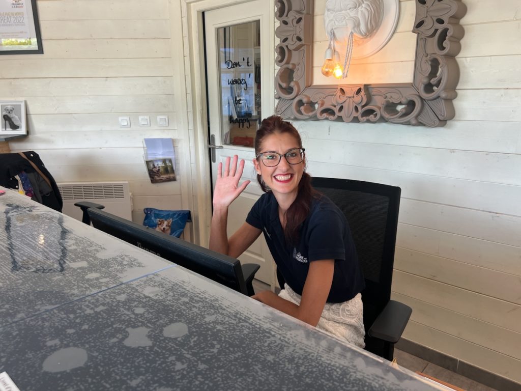 Réceptionniste souriante saluant derrière le bureau