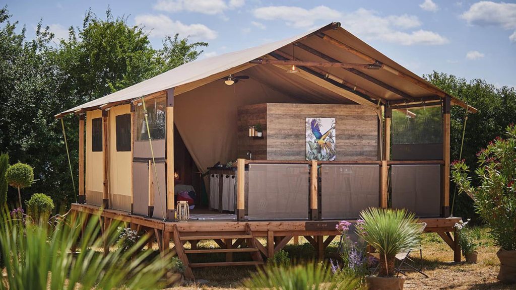 Tente safari luxueuse dans un cadre naturel verdoyant.