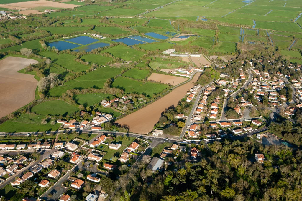 Vue aérienne d'un village et paysages naturels.