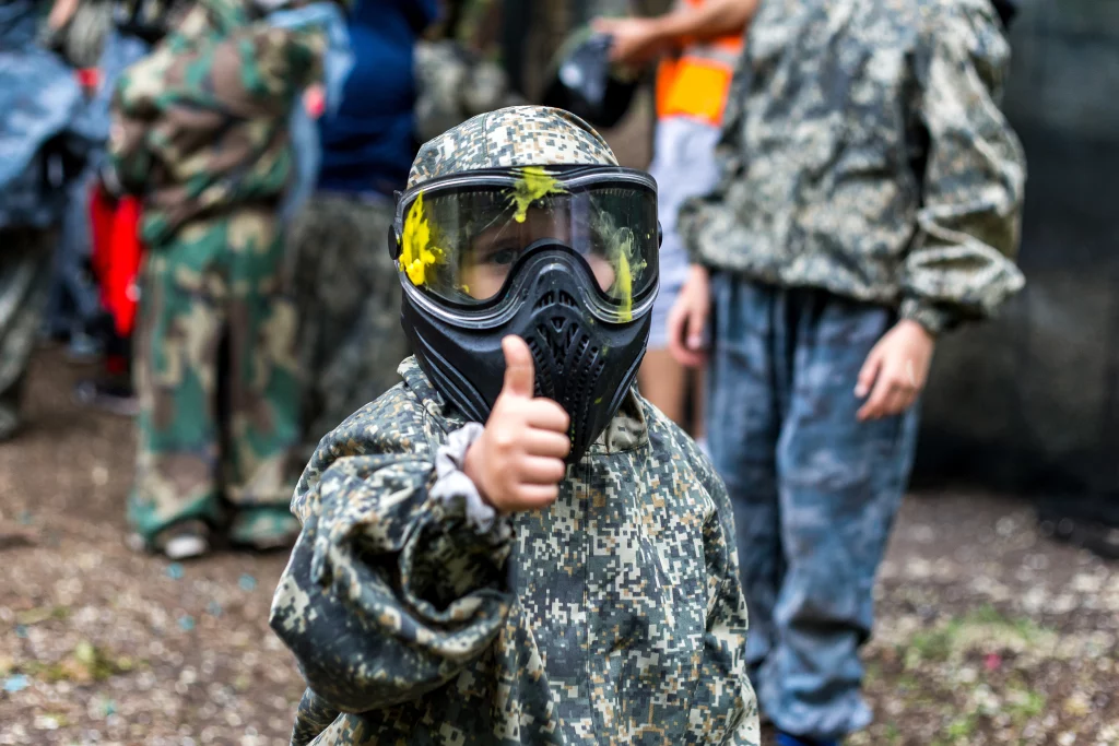 Enfant jouant au paintball avec tenue camouflage.