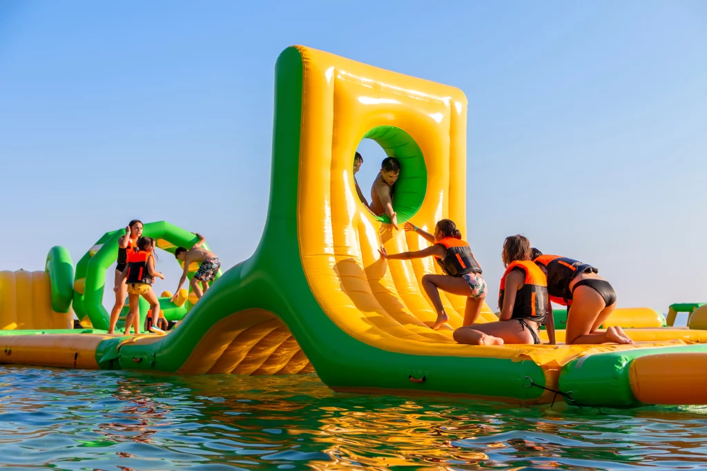 Enfants jouent sur structure flottante gonflable.