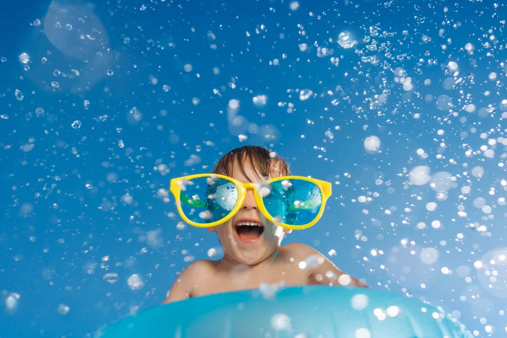 Enfant joyeux avec lunettes en plastique et eau