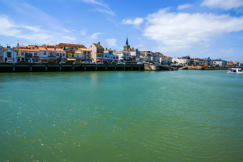 Port de pêche animé avec bateaux et maisons colorées.