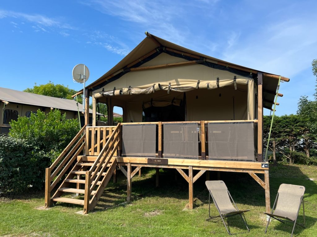 Tente de glamping avec terrasse surélevée extérieure.