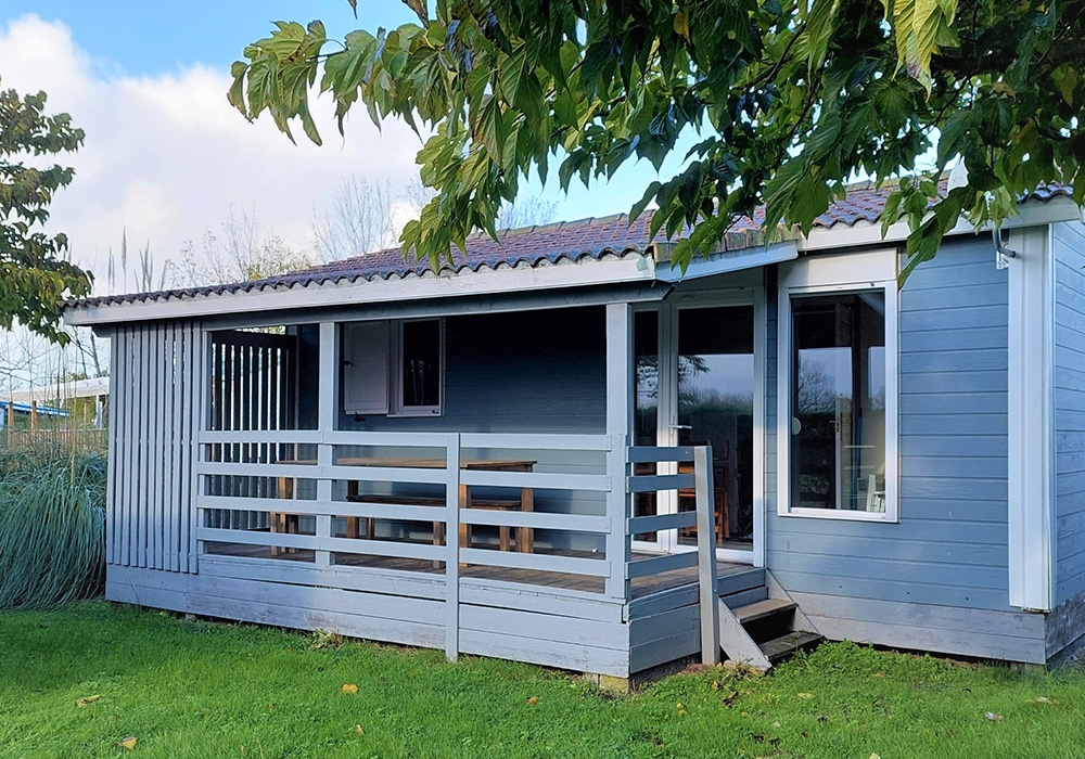 Chalet en bois bleu avec terrasse ensoleillée