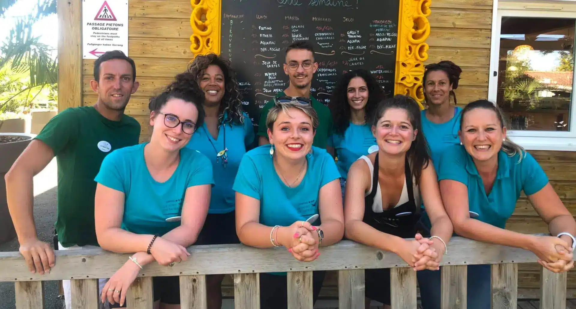 Équipe d'animation du camping devant le programme d'activités